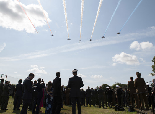 Red Arrows flying overhead with Defence Academy personnel observing.