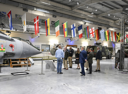 Visitors being given a talk surrounded by military equipment. 