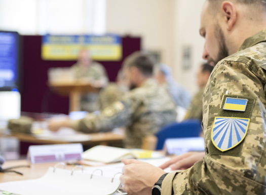 A close angle shot of a Ukrainian Chaplain with his national badge on his sleeve.