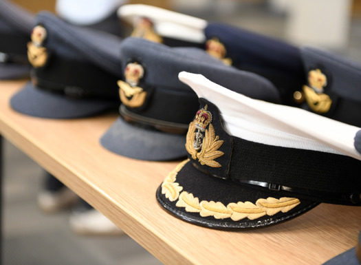 A selection of Royal Air Force uniform caps aligned in a row on a table