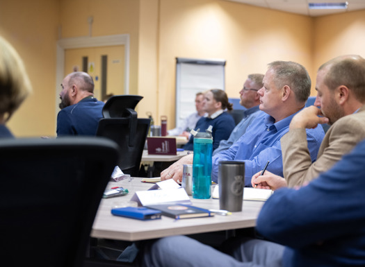 A side view of people sat listening to a presenter