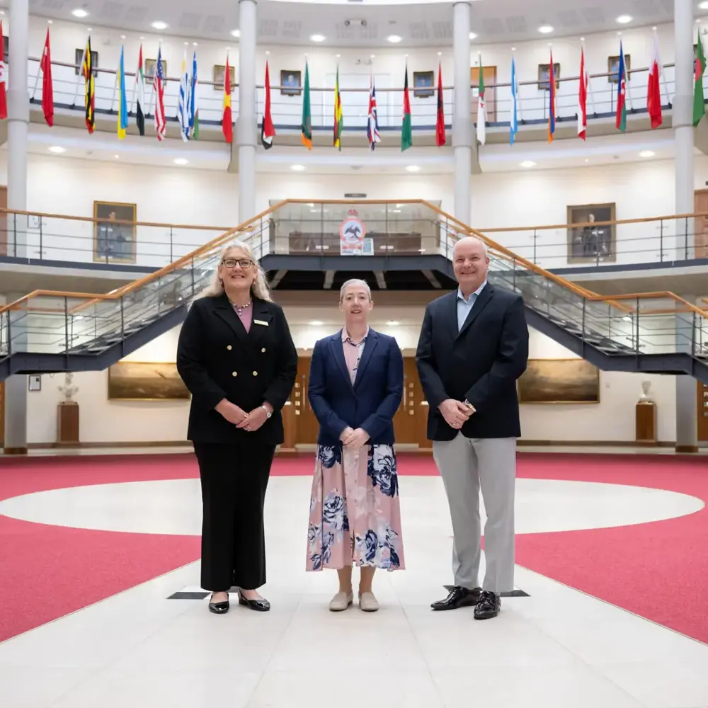 Three individuals stood in the forum surrounded by international flags. 