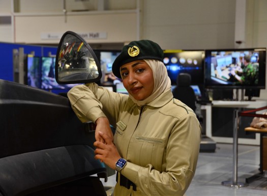 A woman leaning on an armoured vehicle