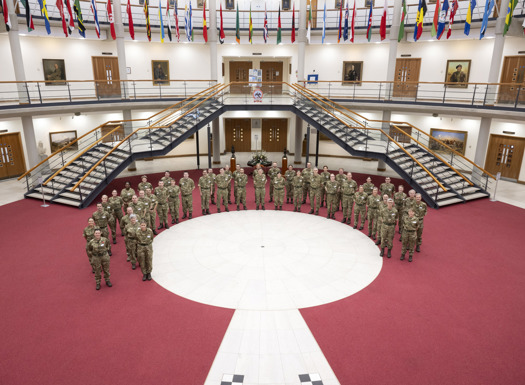 A semi circle of people in military MTP's.