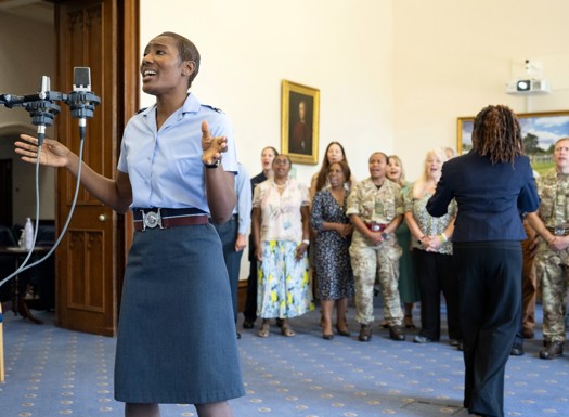 Female RAF officer singing with rest of choir in the background.