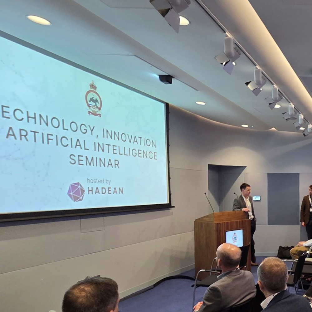 Speaker presenting at a Technology, Innovation and Artificial Intelligence seminar hosted by Hadean with an engaged audience in a modern conference room.