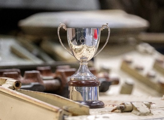 A shiny metal trophy with 'Kavanagh Cup' inscribed.