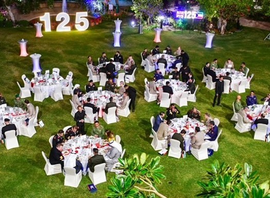 An outside floor plan with round dining tables on grass.