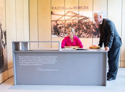HRH The Countess of Wessex sat in front of an exhibit inside the RAch museum with Revd Totten